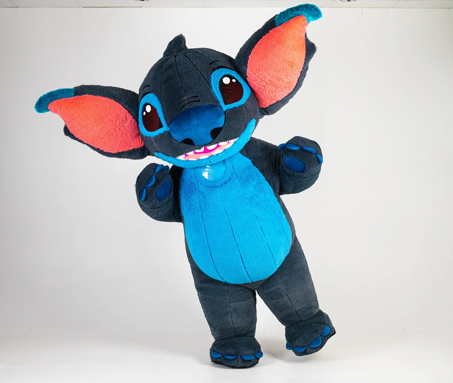 Plush toy resembling a character with blue body, black ears, and red inner ears on a white background
