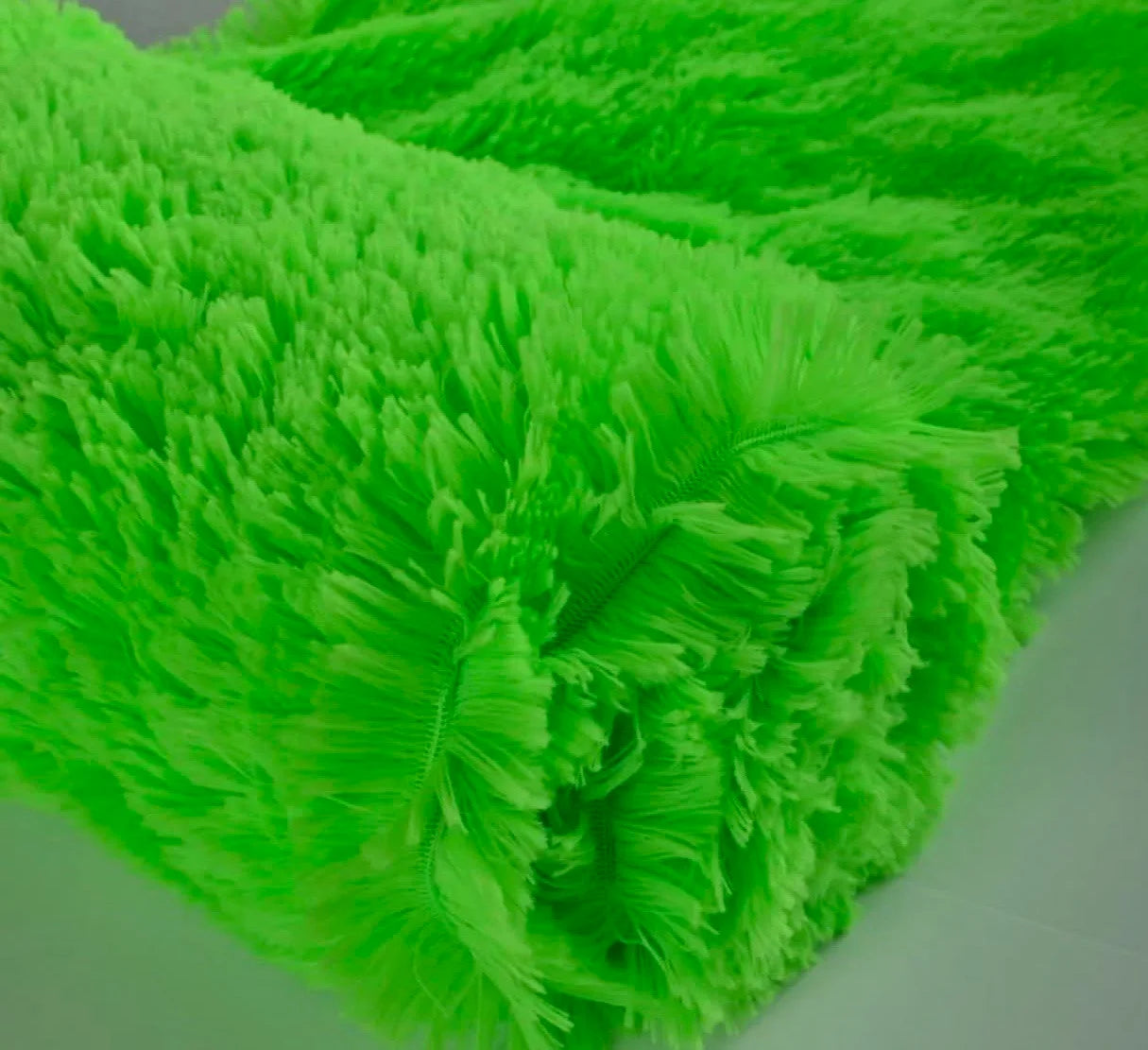 Close-up of bright green textured fabric on a white background